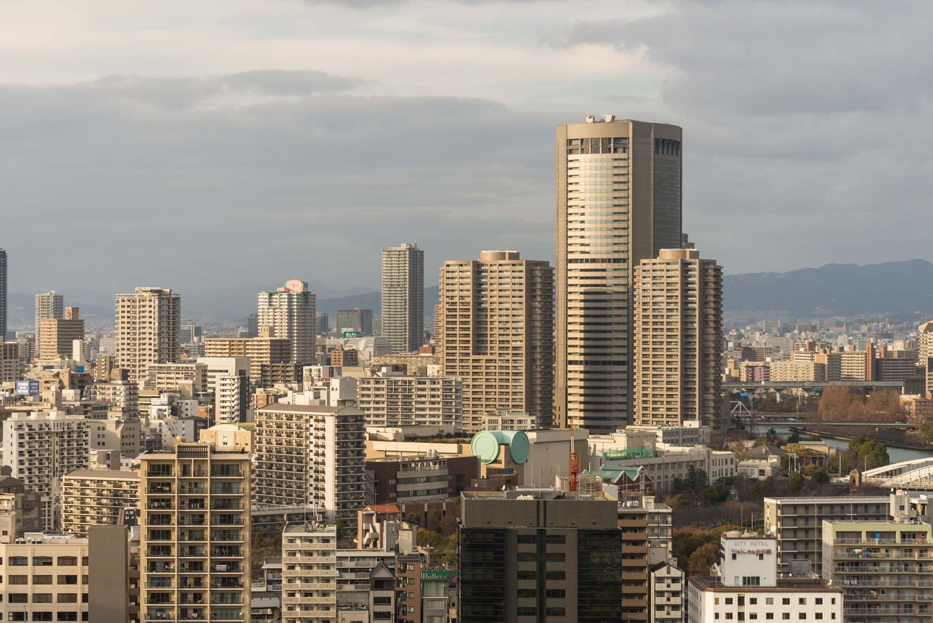 Urban high-rise skyline with towers under a cloudy sky