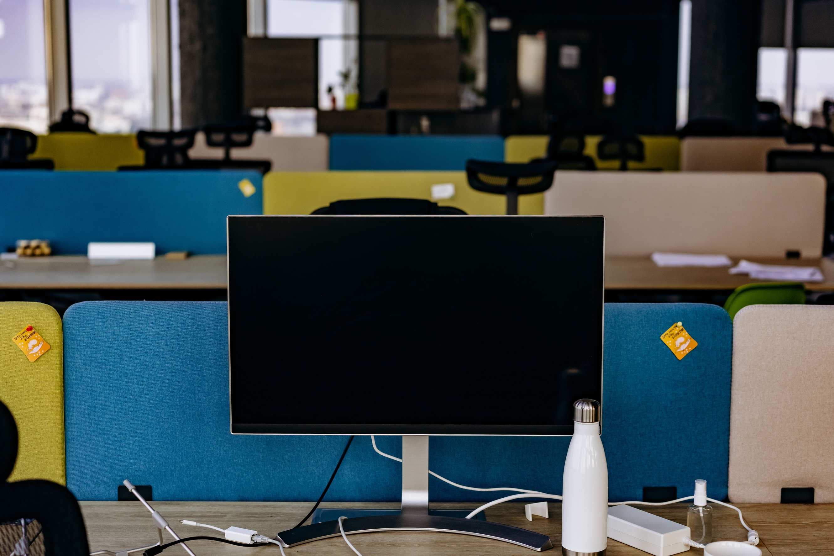 Open office workspace with computers on desks featuring a monitor in an open-plan office